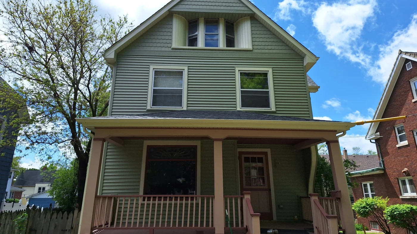 The front of a house with green siding and brown and white trim in Wheaton, IL, by Apex Exteriors, Inc.
