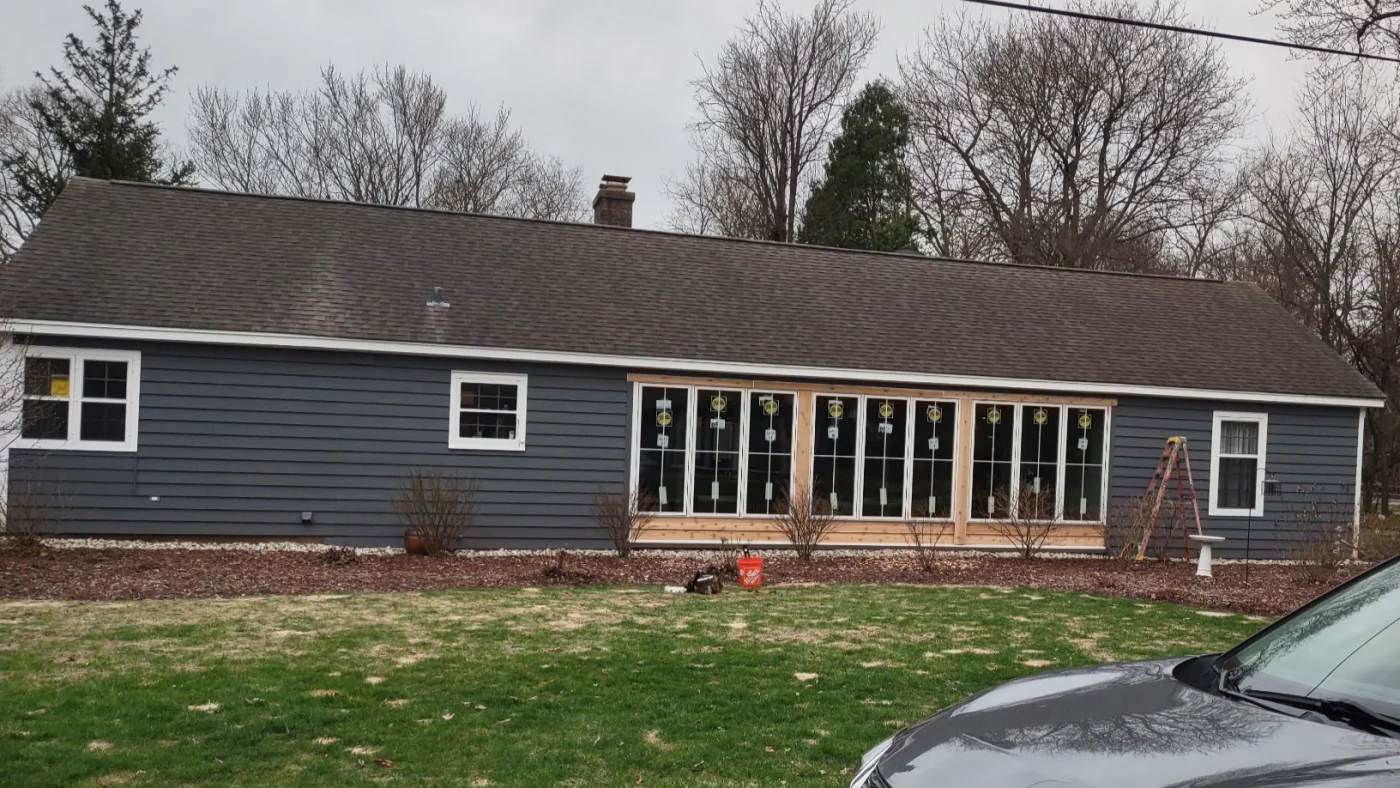 The side of a house with multiple windows in a row and trimmed in white in Elmhurst, IL, by Apex Exteriors, Inc.