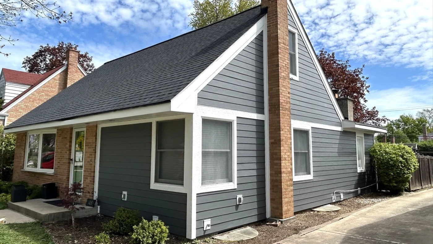 Exceptional Siding Replacement | Hinsdale, IL | Apex Exteriors, Inc. The front and side of a house partially with gray siding and white trim in Hinsdale, IL, by Apex Exteriors, Inc.
