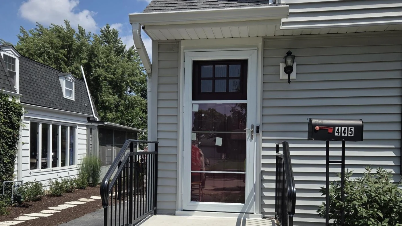 Gorgeous Entry Doors | Hinsdale, IL | Apex Exteriors, Inc. The front of a house with gray siding and a gorgeous brown front entry door in Hinsdale, IL, by Apex Exteriors, Inc.