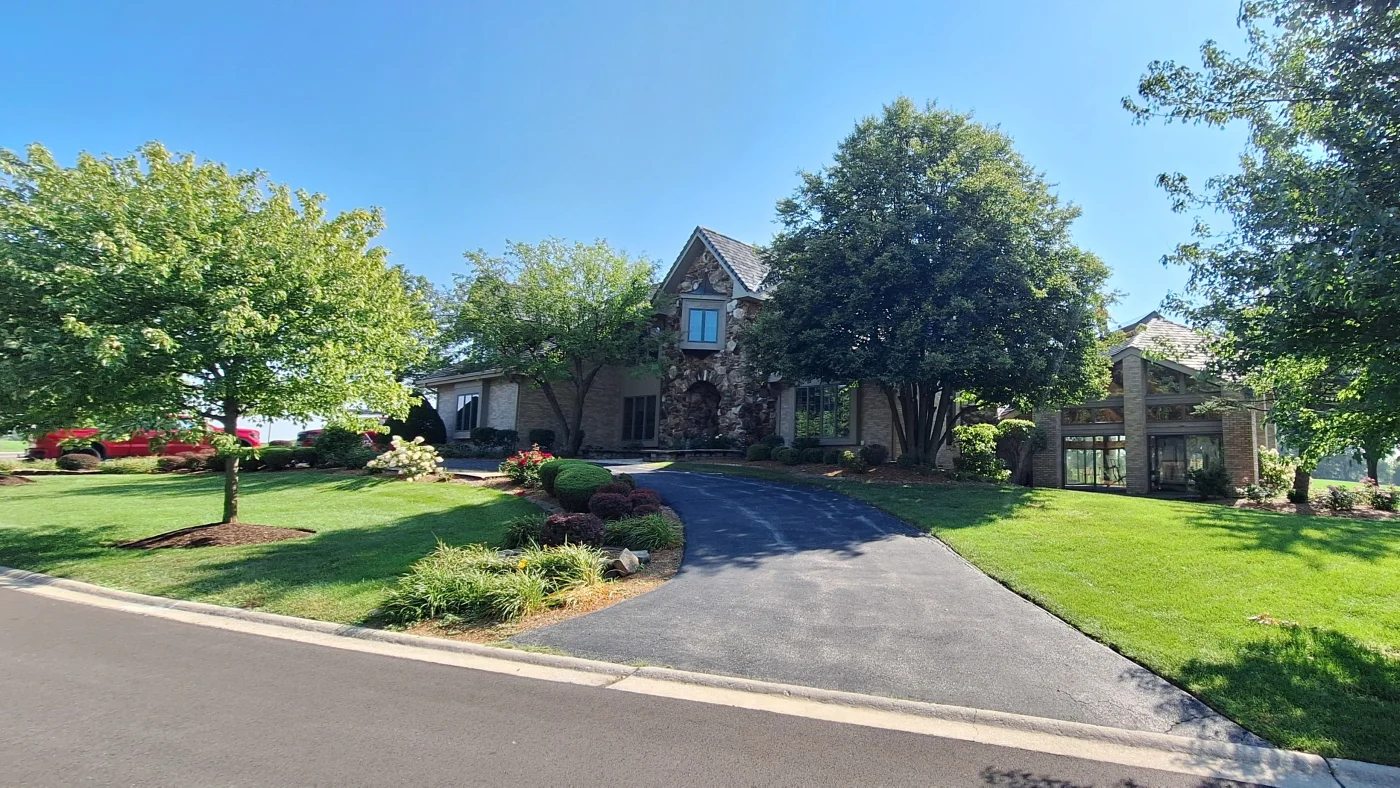 Incredible Roof Replacement Services | Glen Ellyn, IL | Apex Exteriors, Inc. The front of a large house with a light brown roof in Glen Ellyn, IL, by Apex Exteriors.
