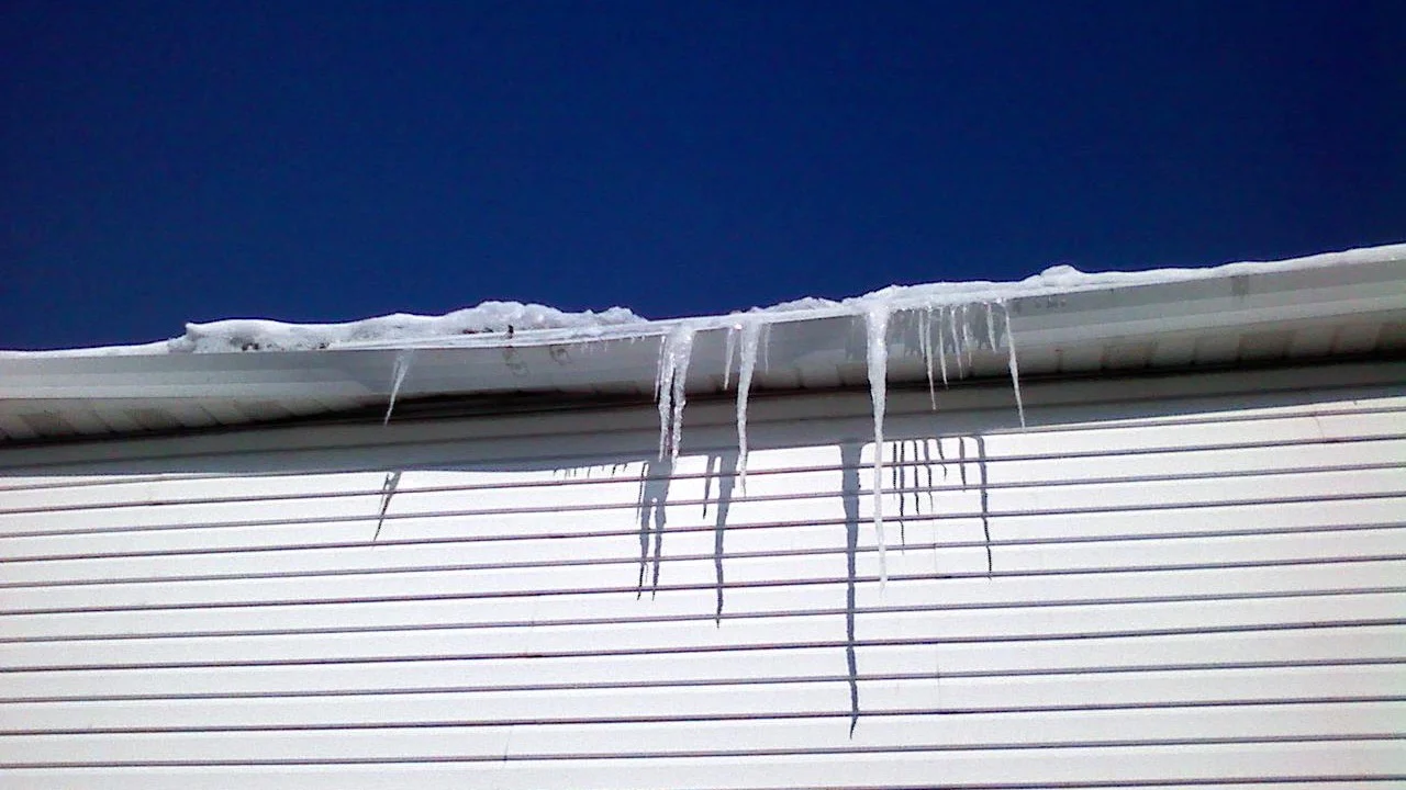 Masterful Roofing Contractor Barrington Il Apex Exteriors The roof line of a house with ice cicles hanging from it in Barrington, IL, by Apex Exteriors, Inc.