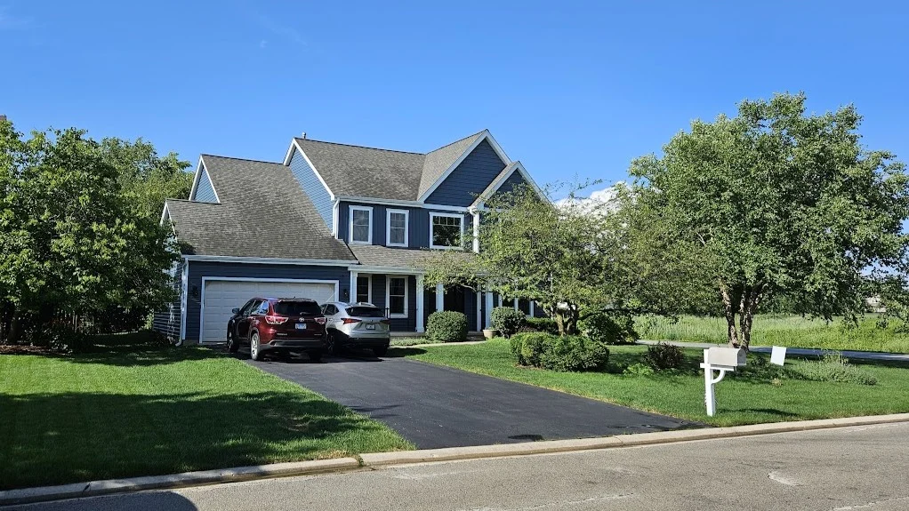 Remarkable Exterior Home Remodeling | Bloomingdale, IL | Apex Exteriors, Inc. The front of a house with blue siding and gorgeous windows trimmed in white in Bloomingdale, IL, by Apex Exteriors, Inc.