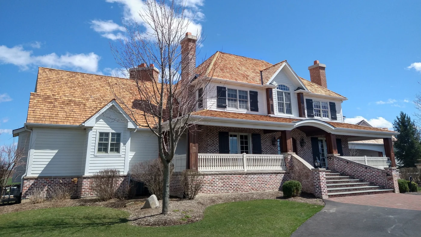 The front of a house with white siding and a tan roof in Elmhurst, IL, by Apex Exteriors, Inc.