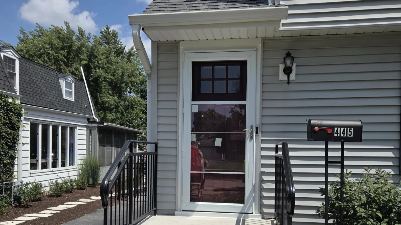 Stunning Replacement Entry Door Services | Glenview, IL | Apex Exteriors, Inc. The brown front door of a house with light gray siding in Glenview, IL, by Apex Exteriors, Inc.