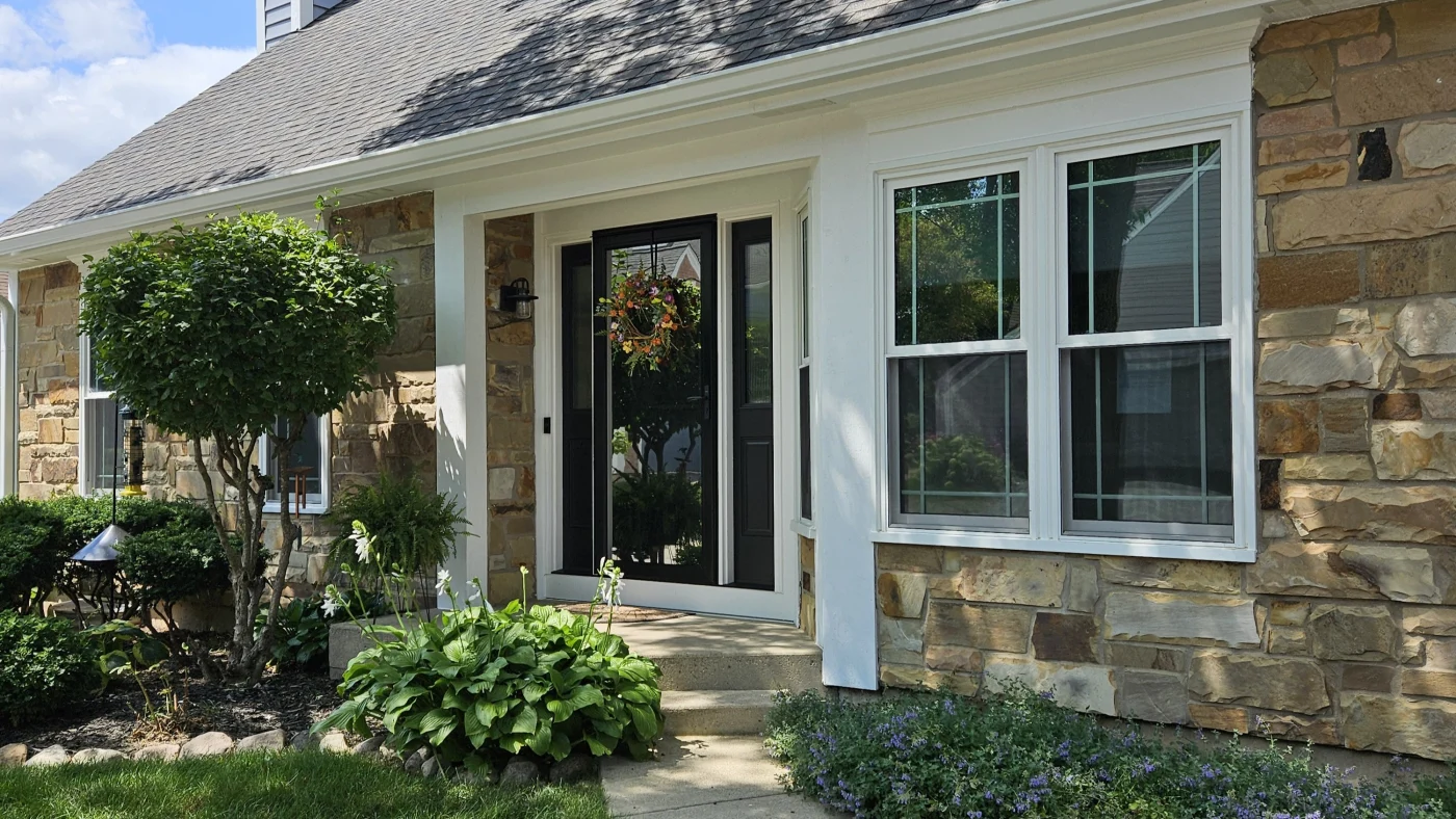 Stylish entry with a sleek, upgraded front door that enhances security, boosts energy efficiency, and pairs beautifully with the home's stone accents and manicured landscaping.