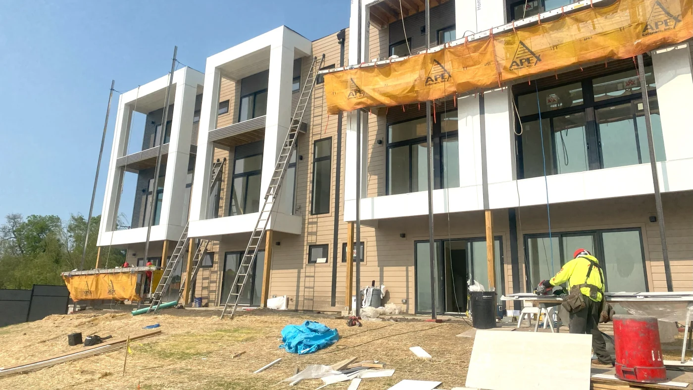 Outstanding Multi-Family Exterior | Elgin, IL | Apex Exteriors Inc. Modern multi-family building under construction with clean-lined façade, large windows, and exterior finishing in progress, featuring the Apex Exteriors crew and equipment onsite.
