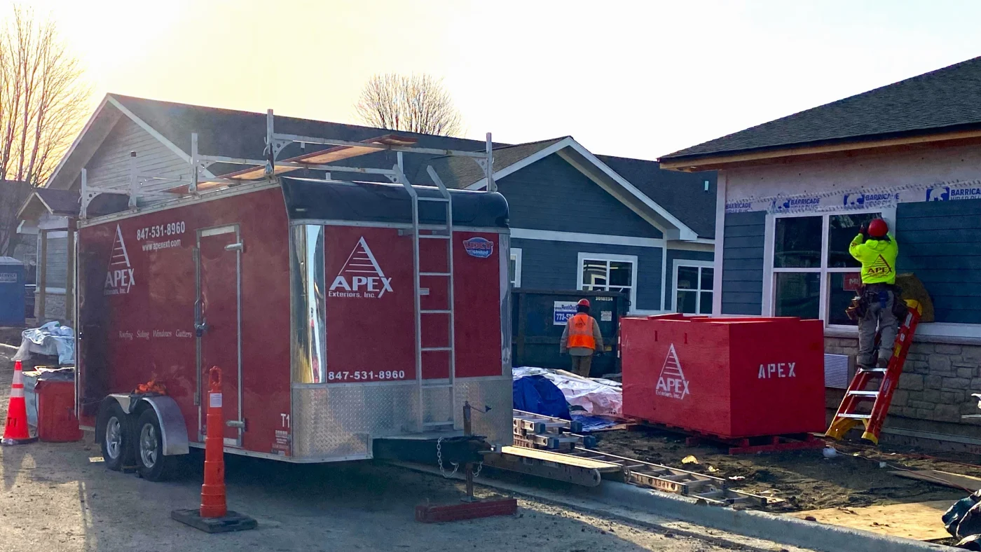 Exceptional Commercial New Construction | Bartlett, IL | Apex Exteriors, Inc. Large-scale multi-unit construction site with framing, siding prep, and Apex Exteriors crews working across multiple buildings, highlighting steady progress on a growing residential development.
