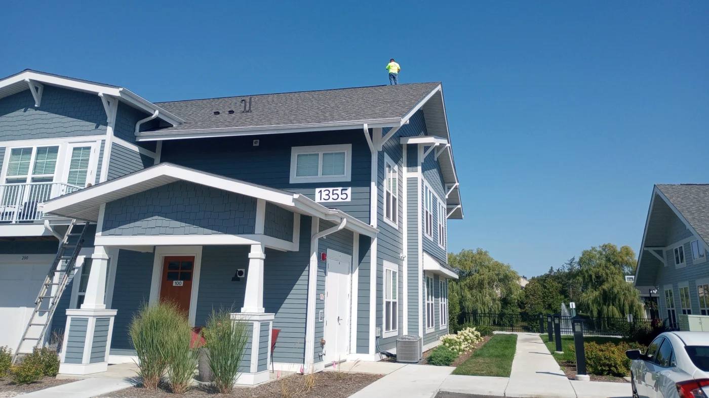 Reliable Commercial New Construction | Bartlett, IL | Apex Exteriors, Inc. Apex Exteriors crew performing exterior installation at a residential jobsite, with branded trailer, materials staged on-site, and detailed siding work underway.
