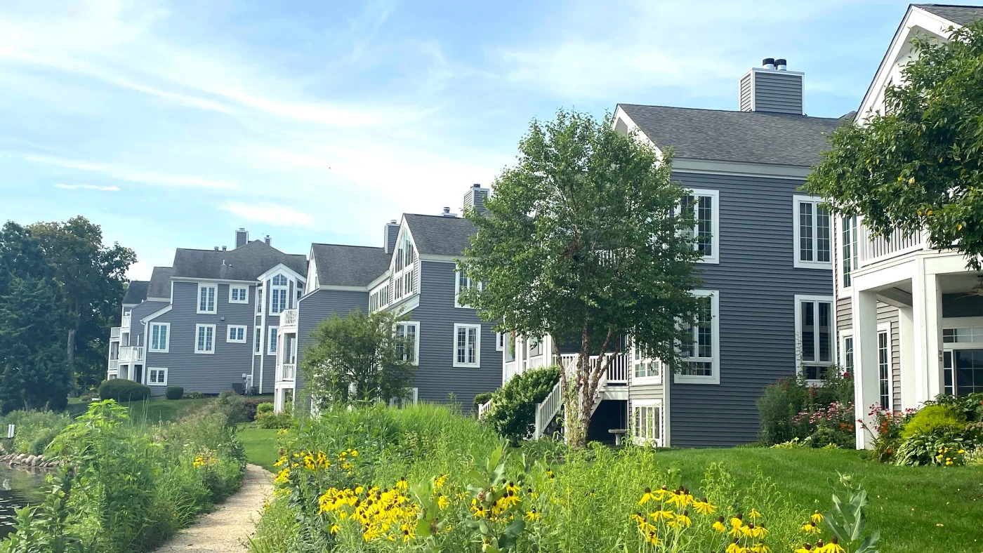 Remarkable HoA Exterior Services | Elgin, IL | Apex Exteriors Inc. Multi-family residential buildings with updated siding and trim, set along a landscaped path with native plants.