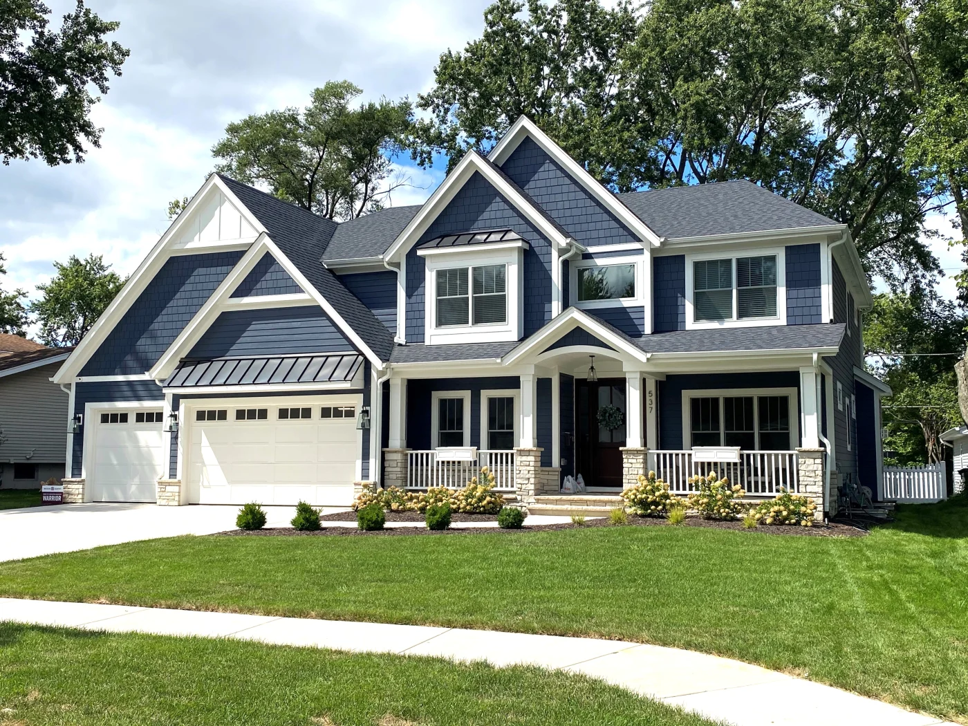Colonial Cook County home with blue and off-white siding and snow on roof