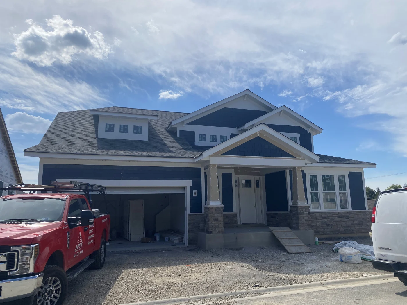 A full view of a lovely, brand-new home with stone veneer siding.