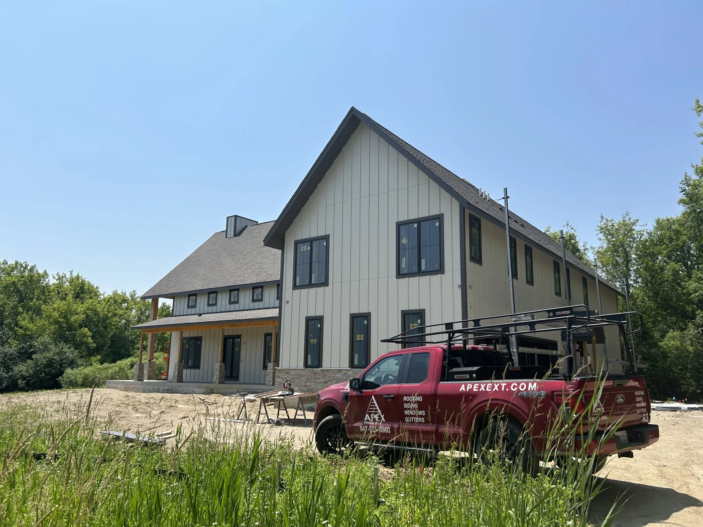 A shot of 3 roofers carefully installing a roof on a new home.